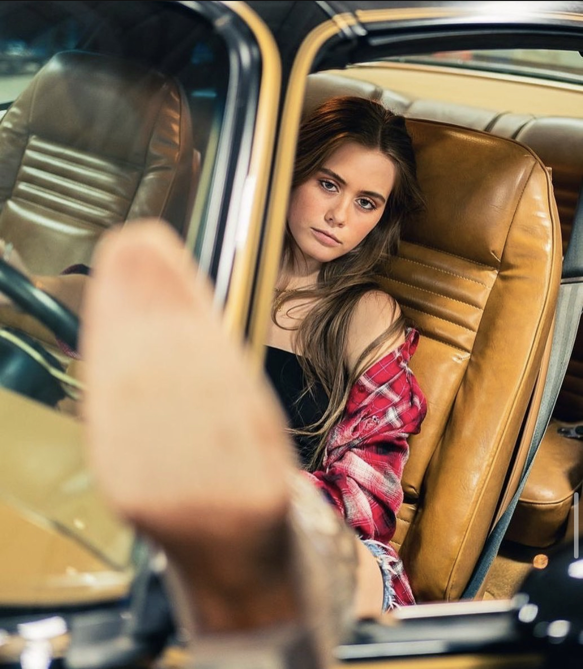 Mackenzie modeling in a car with her foot out the window from the magazine feature